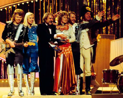 ABBA on stage following their historic win with manager Stikkan "Stig" Anderson and orchestra conductor Sven-Olof Walldof (image via
