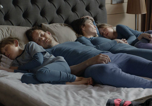 Exhausted after their first day of skiing, Tomas, Ebba, Harry and Vera sleep together, one last moment of familial bliss before their world takes a turn for the troubled and dark (Image via Hitfix)
