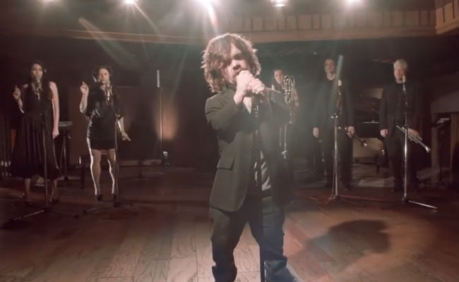 Peter Dinklage belts out a a Coldplay-crafted tune for the first ever US Red Nose Day LIve Benefit Show on NBC, confirming he is "Still Going Strong" (image via YouTube (c) NBC)